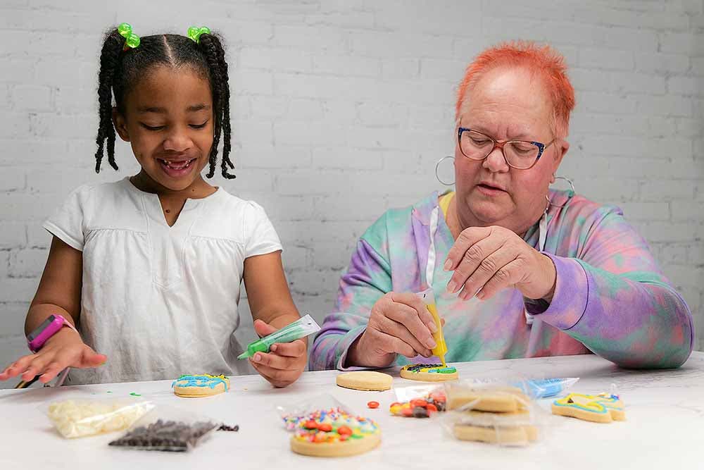 Woman and girl decorating cookies